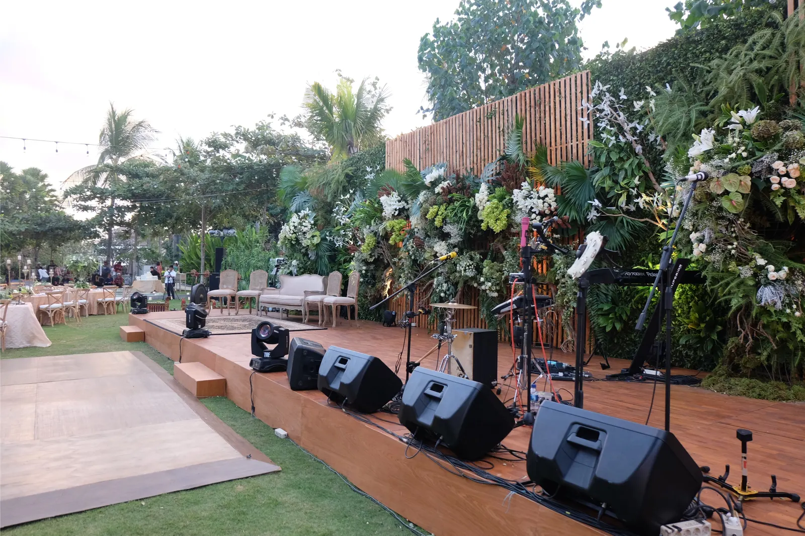Timber stage with the band set up, planting and florals along the back wall