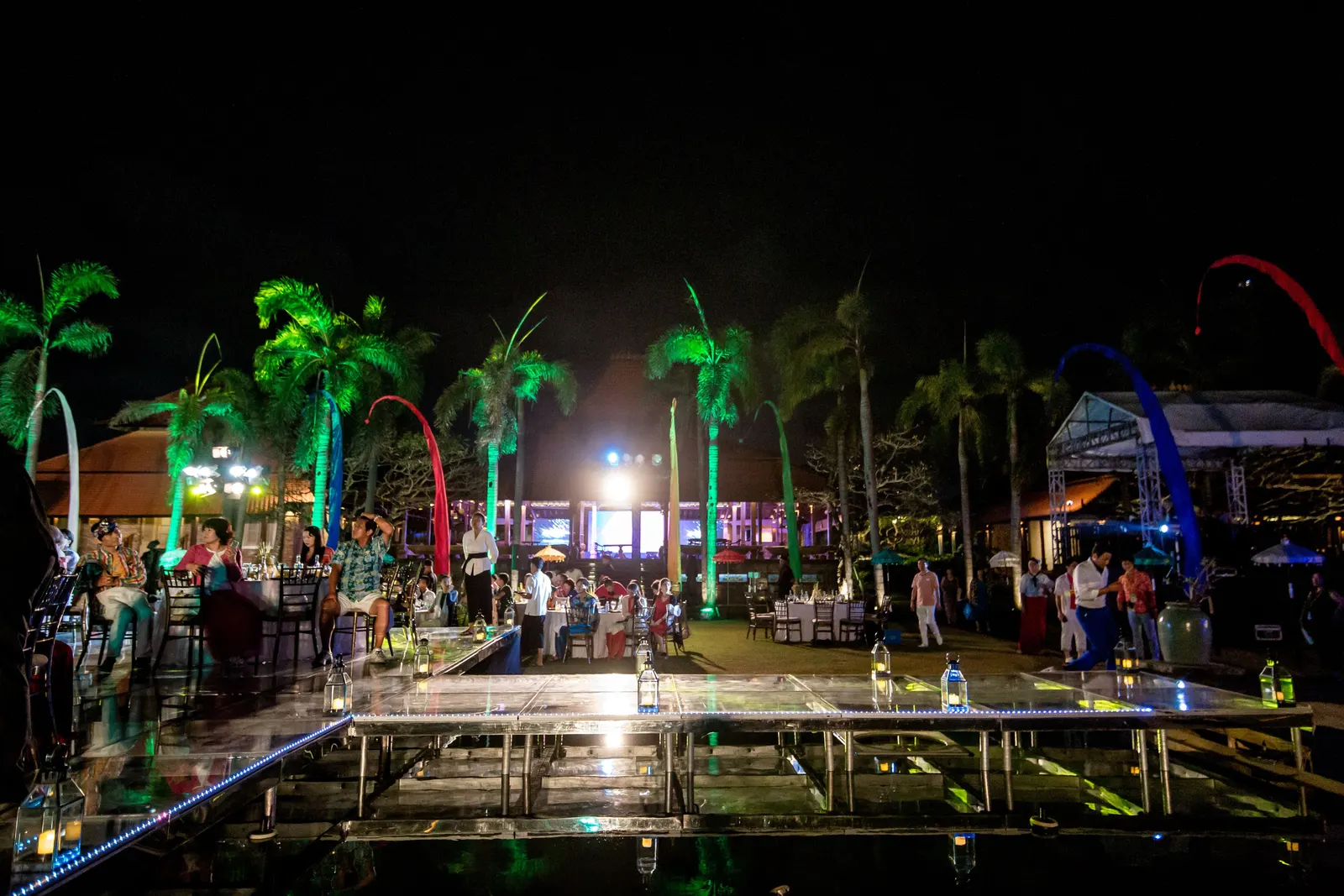 Acrylic floating stage over the water at night, guests standing on the clear panels