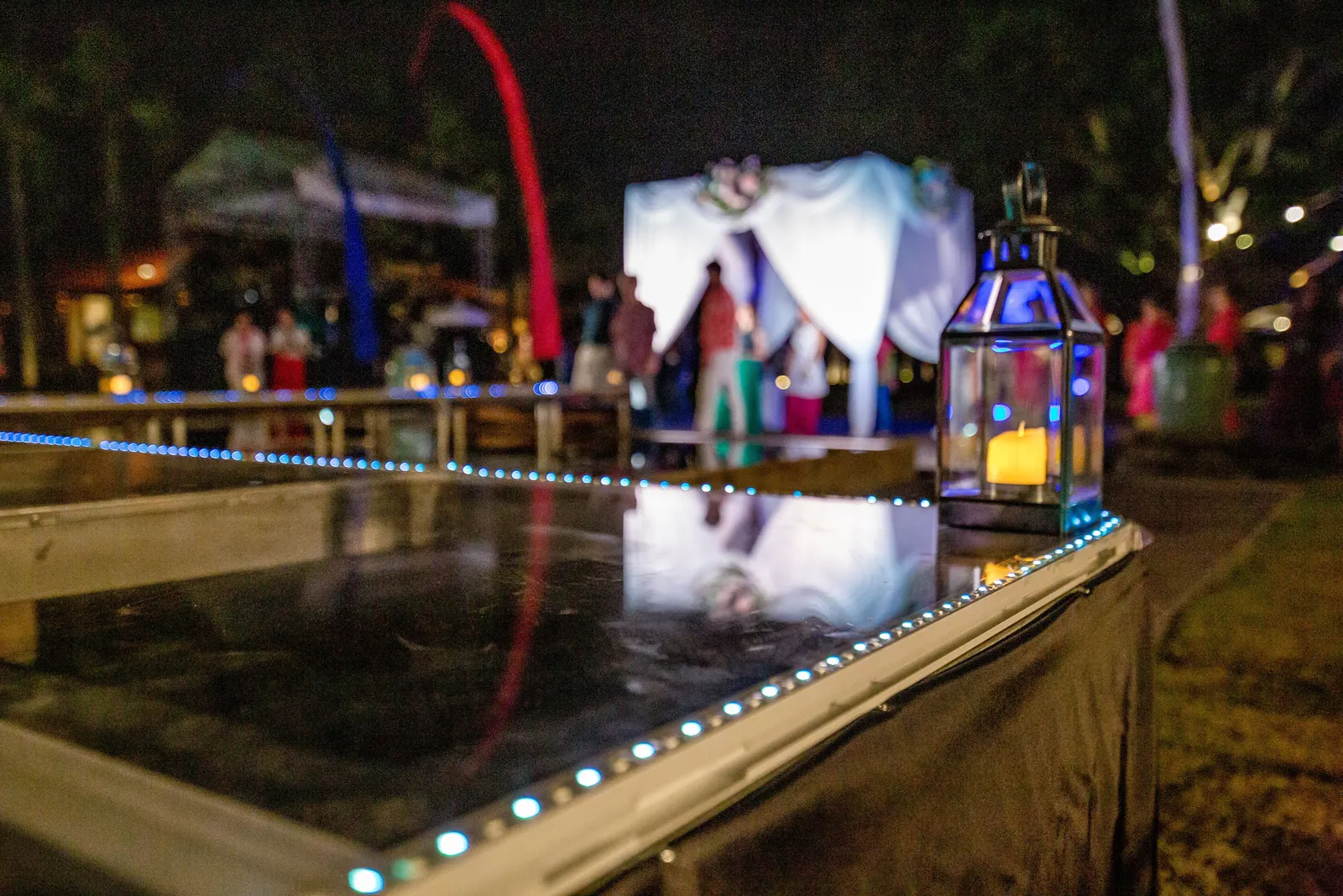 Acrylic floating stage lit from beneath, lanterns along the edge, stage screen behind